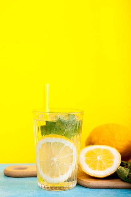 Lekker en biologisch detoxwater met citroenen op gele achtergrond in studiofoto