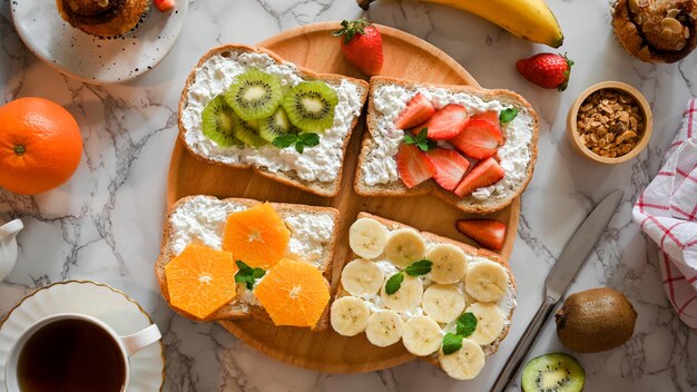 Lekker gezond fruit op een toast met kwark op een houten bord en een kopje koffie bovenaanzicht