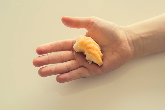 lekker klein paaskoekje op de hand van een kind op een lichte achtergrond