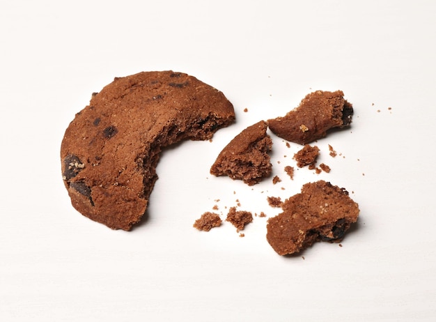 Lekker koekje met chocoladerepen en kruimels op witte achtergrond