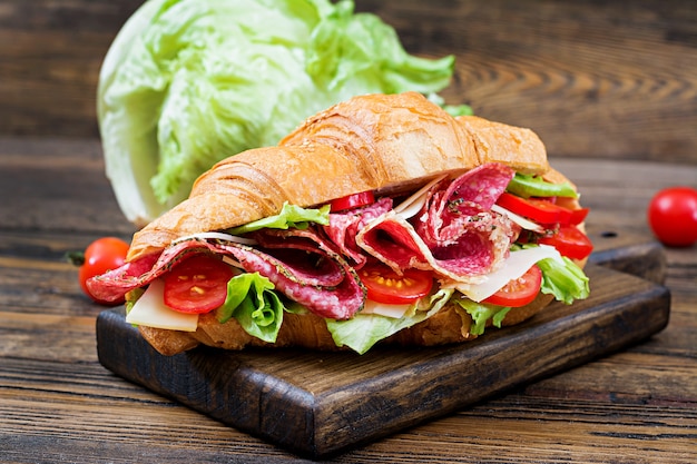 Lekker ontbijt. Smakelijke croissant met salami en kaas en tomaten