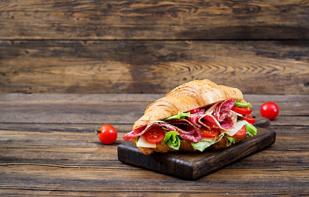 Lekker ontbijt. Smakelijke croissant met salami en kaas en tomaten