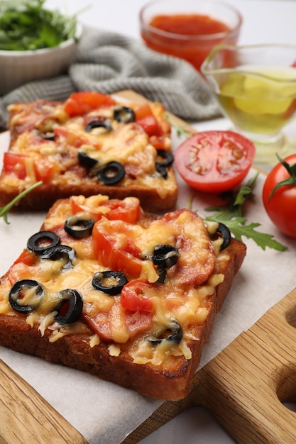 Lekker pizza toast en ingrediënten op een witte tafel close-up