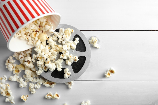 Lekker popcorn en filmrol op een witte houten achtergrond