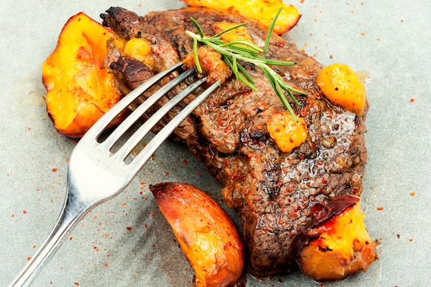 Foto lekker rundvleessteak met perzik in fruitmarinade closeup