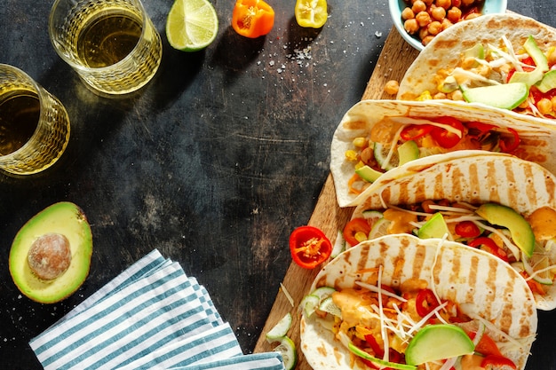 Lekker smakelijke verse zelfgemaakte veganistische taco's met kikkererwten en groenten aan boord geserveerd. Bovenaanzicht.