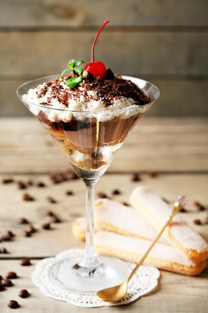 Lekker tiramisu-dessert in glas op houten achtergrond