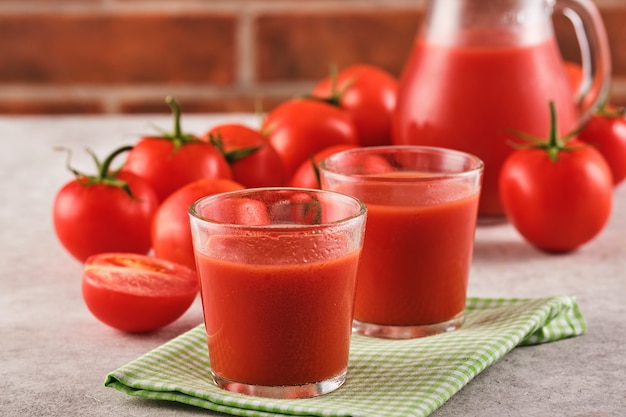 Lekker tomatensap in een glas met rijpe rode tomaten.