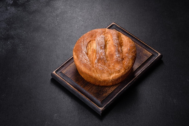 Lekker vers gebakken in de oven wit brood op een donkere betonnen ondergrond