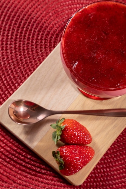 Lekkere aardbeienmousse in glas met jam erop.