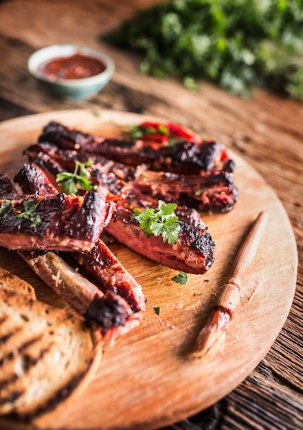 Lekkere barbecue gegrilde varkensribbetjes met chili pepers en peterselie kruiden.