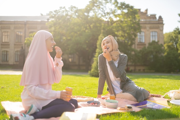 Lekkere bessen eten. Glimlachende moslimstudent die buiten luncht en lekkere bessen eet