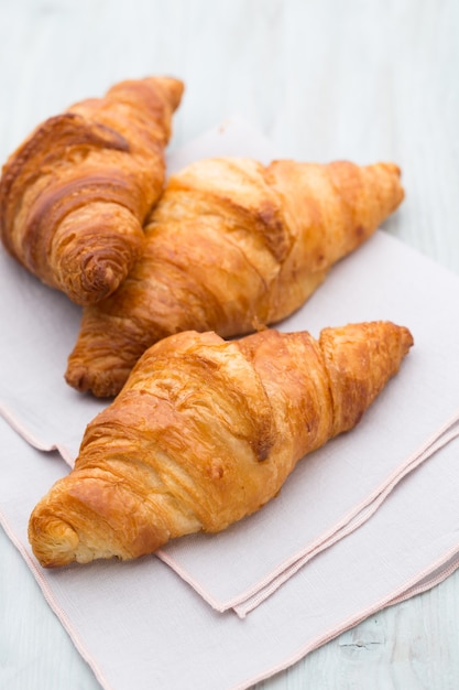 Lekkere boterachtige croissants op oude houten tafel.