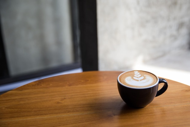 Lekkere cappuccino met prachtige latte art op houten tafel in het café