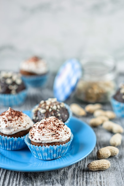 Lekkere chocolade cupcakes op een grijze houten achtergrond met chocolade en noten