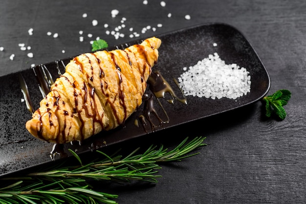 Lekkere croissant met chocolade bemand op zwarte houten achtergrond