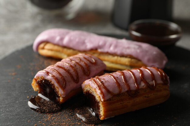 Lekkere eclairs met heerlijke topping op zwarte schaal, close-up