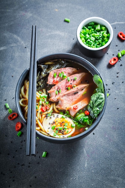 Lekkere en hete Ramen-soep geserveerd met bieslook en sesam