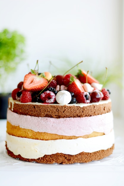 Foto lekkere en mooi gedecoreerde cake met bessenroom en vers fruit