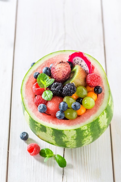 Lekkere fruitsalade in watermeloen in zonnige keuken