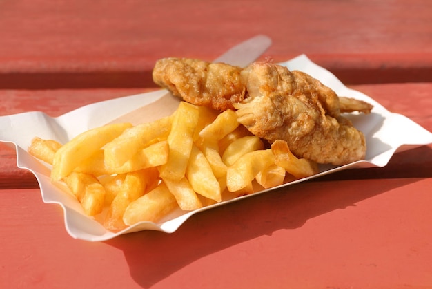 Lekkere gebakken fish and chips op houten bankje