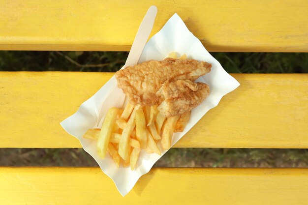 Lekkere gebakken fish and chips op houten bankje