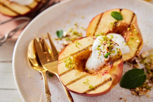 Foto lekkere gegrilde perziken met yoghurt en pistachenoten op plaat