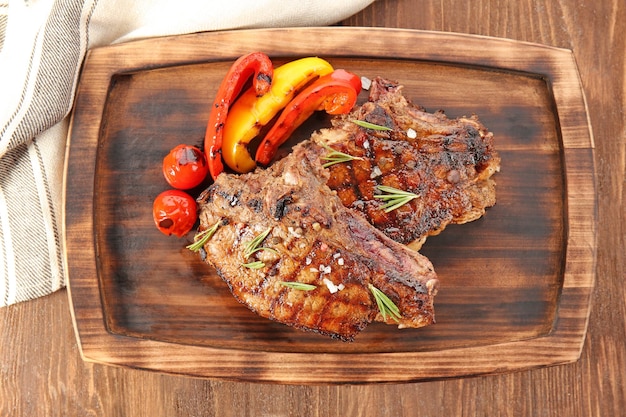 Lekkere gegrilde steaks met groenten op een houten bord