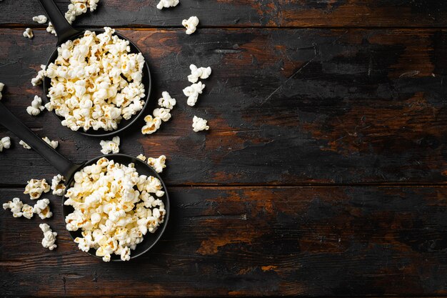 Lekkere gezouten popcorn op oude donkere houten tafel achtergrond bovenaanzicht plat lag met kopieerruimte voor tekst