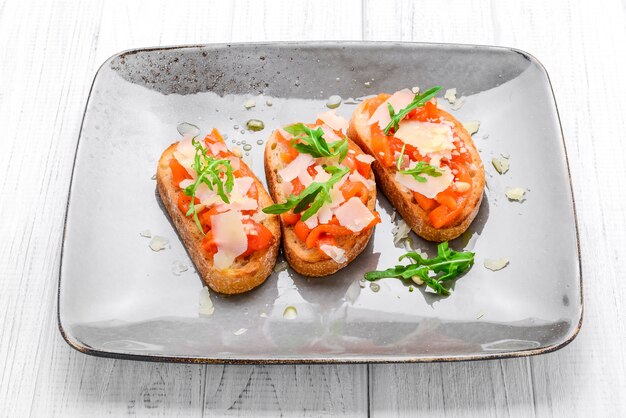 Lekkere hartige Italiaanse hapjes, of bruschetta, op plakjes geroosterd stokbrood gegarneerd met basilicum