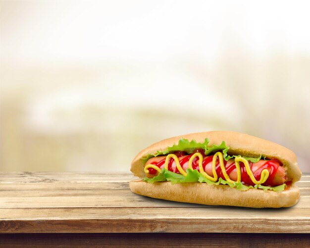 Lekkere hotdog met mosterd op houten tafel