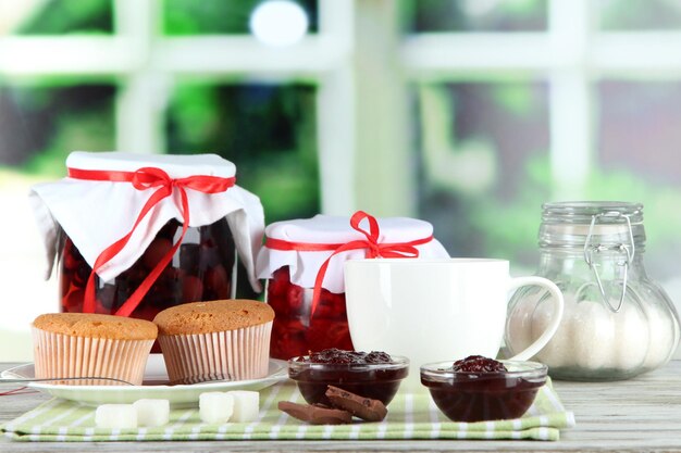 Lekkere jam in banken op servet op houten tafel op vensterachtergrond