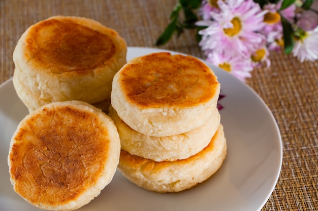 Lekkere kaas pannenkoeken met jam op een bord op een bruine achtergrond. ontbijt