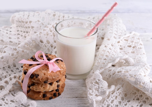 Lekkere koekjes en glas melk op een houten achtergrond kleur