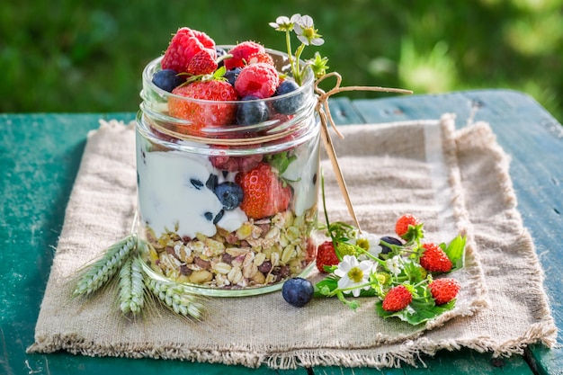 Lekkere muesli met yoghurt en bessen op zonnige dag