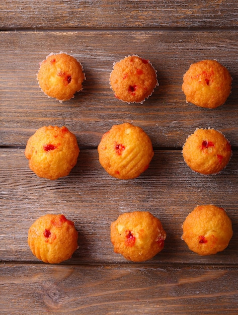 Lekkere muffins met rode aalbes op houten achtergrond