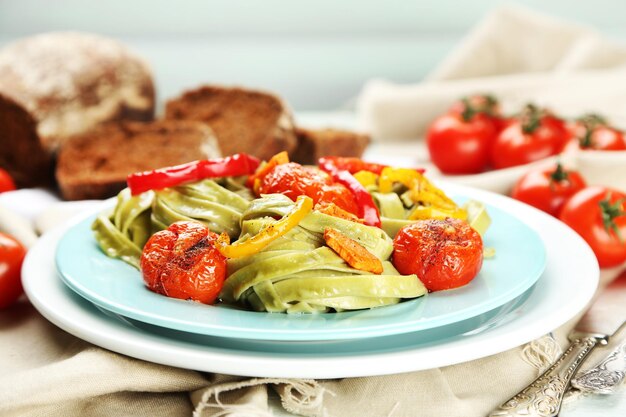 Lekkere pasta met peper wortel en tomaten op houten tafel achtergrond