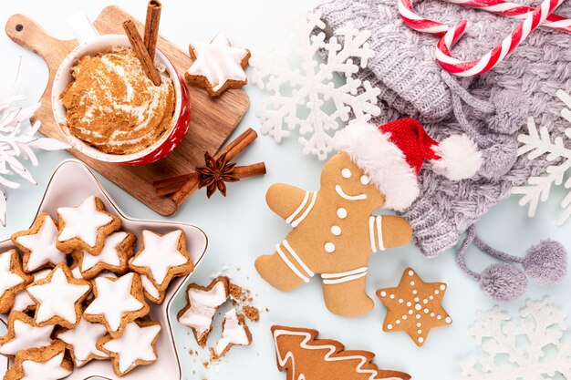 Lekkere peperkoekkoekjes en kerstdecor op pastelachtergrond.