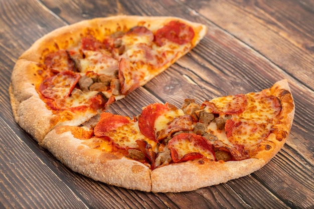 Lekkere pizza met gemengd vlees op houten tafel.