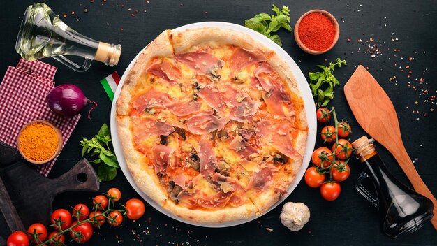 Lekkere pizza met prosciutto Parmezaanse kaas en champignons op een houten achtergrond Bovenaanzicht Gratis kopieerruimte