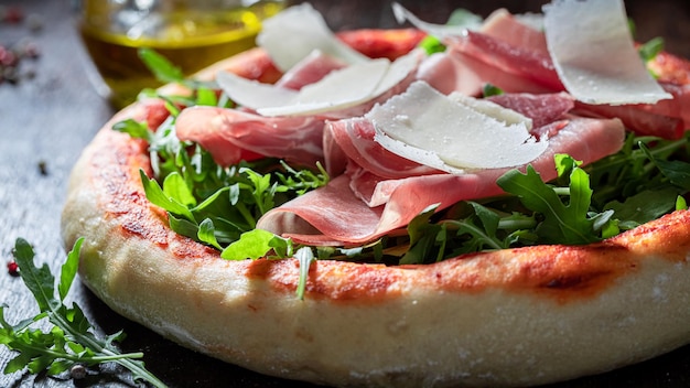 Lekkere pizza Parma gemaakt van prosciutto ham parmezaan en rucola