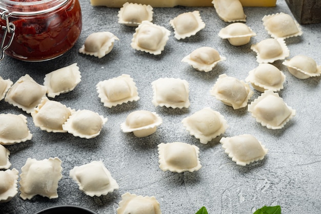 Lekkere rauwe ravioli met bloem en basilicum set, op grijze achtergrond, met copyspace en ruimte voor tekst