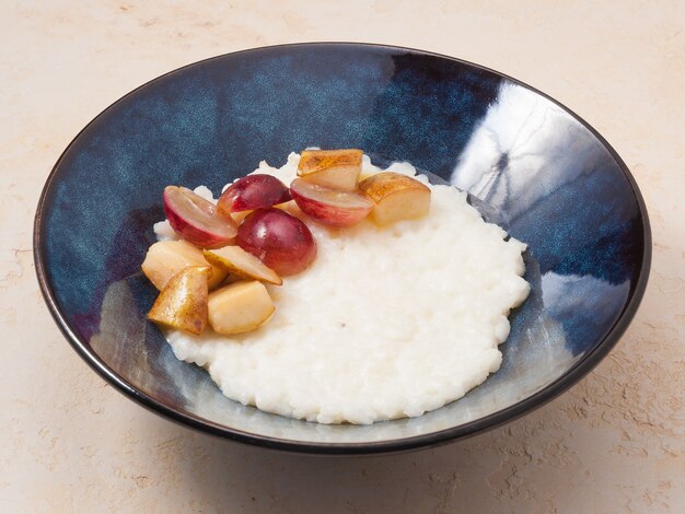 Lekkere rijstepap met melk met gekarameliseerde peren en druiven