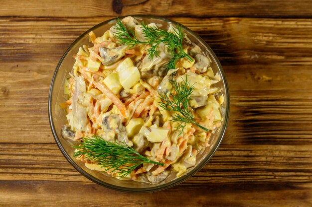 Lekkere salade met kipfilet geroosterde champignons wortelen geraspte kaas eieren en mayonaise op houten tafel Bovenaanzicht