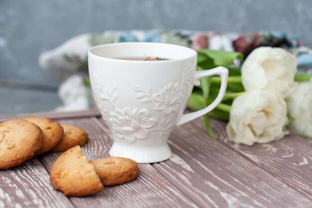 lekkere snack. kopje thee en een stapel koekjes.