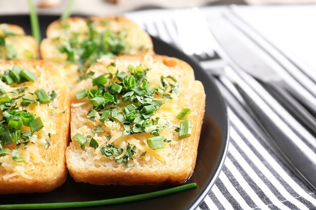 Lekkere sneetjes brood met knoflookkaas en kruiden op bord