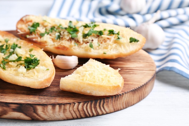 Lekkere sneetjes brood met knoflookkaas en kruiden op houten snijplank