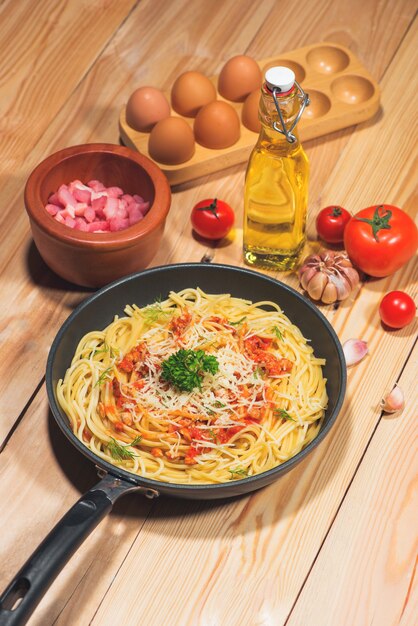 Lekkere spaghetti met tomatensaus en vlees in pan op houten tafel.