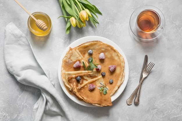 Lekkere traditionele Russische pannenkoeken, thee, honing. Lente.