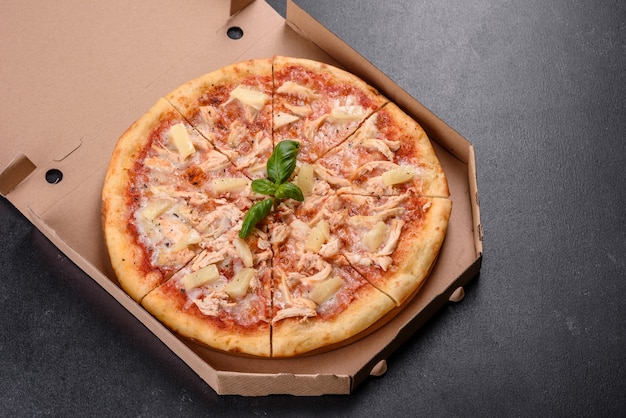 Lekkere verse ovenpizza met tomaten, kaas en ananas op een donkere betonnen achtergrond